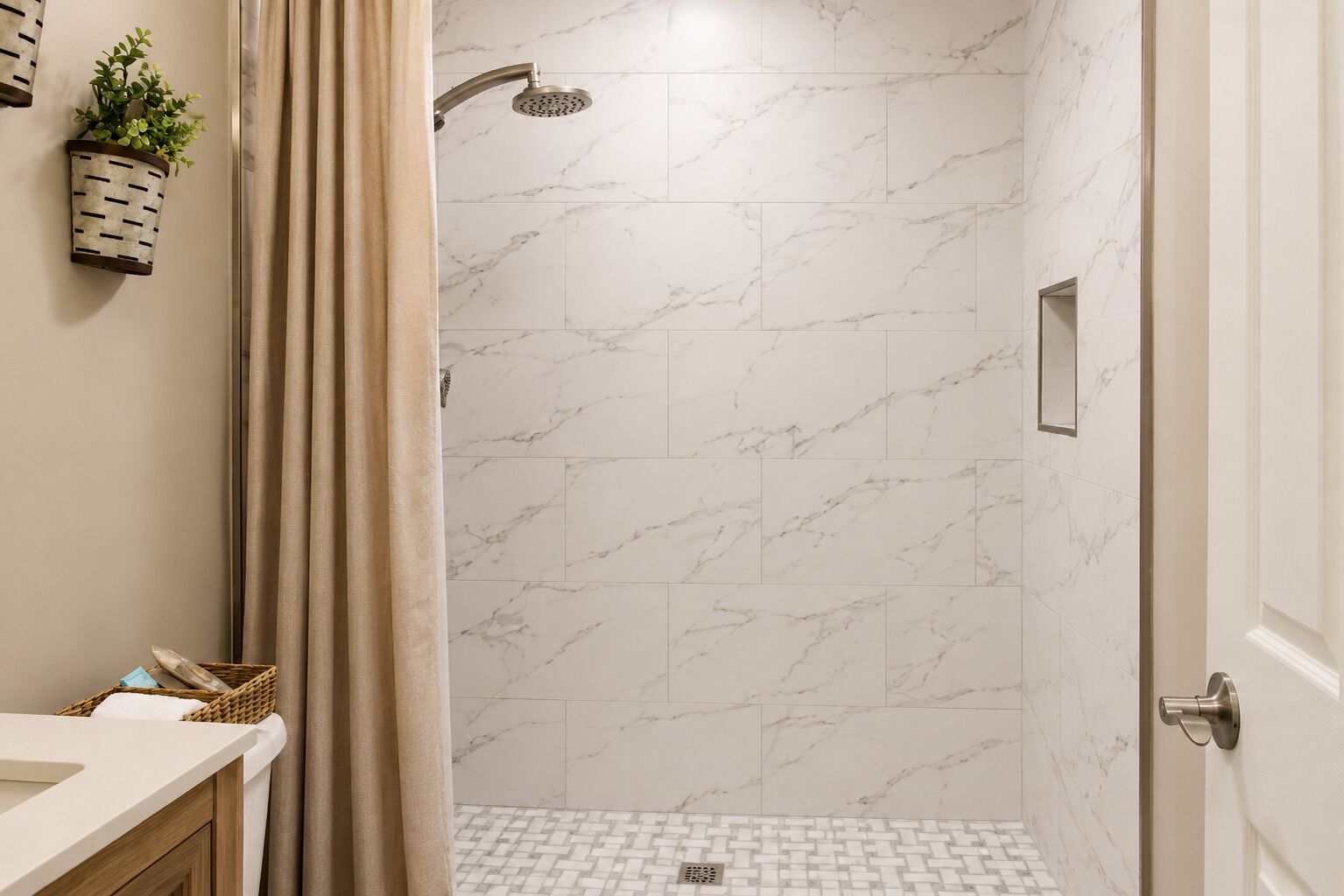 A bathroom with a shower, marble tiles, a wooden vanity, and a potted plant.