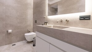 A modern bathroom with a large mirror, two sinks, and a toilet. - Phaedrus Living Athens Residences Golden (Athens)