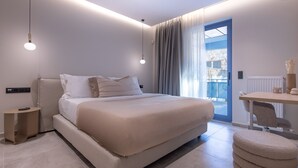 A modern bedroom with a large bed, bedside tables, a desk, and a view of the outside. - Phaedrus Living Athens Residences Golden (Athens)