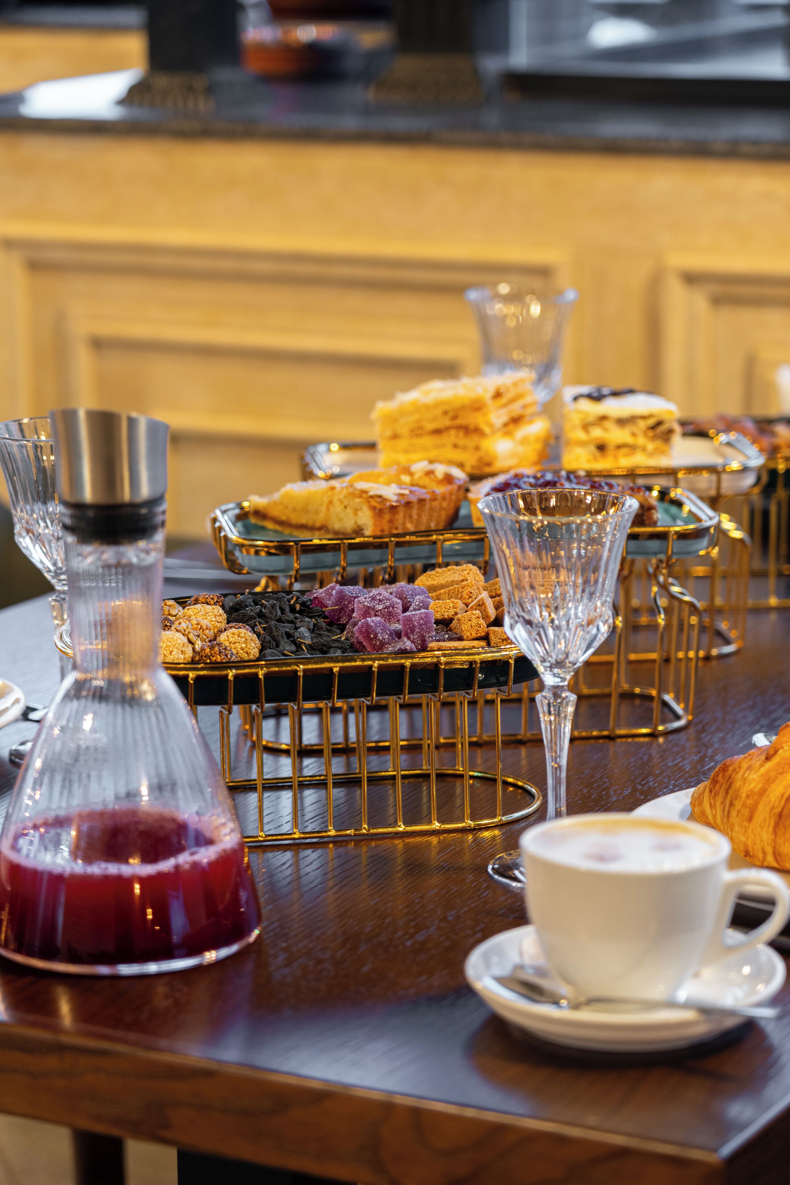 A table with various pastries, a coffee cup, and a decanter.