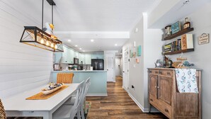 Een moderne keuken met witte kasten, een centraal eiland en een hangende lamp.