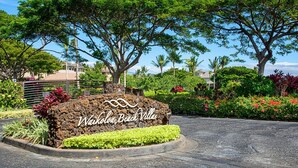 A sign for Waikoloa Beach Villas with a landscaped garden and tropical trees. - Newly Renovated Top Floor Luxury Waikoloa Beach Villa F32, Fairway Views!! (Waikoloa)