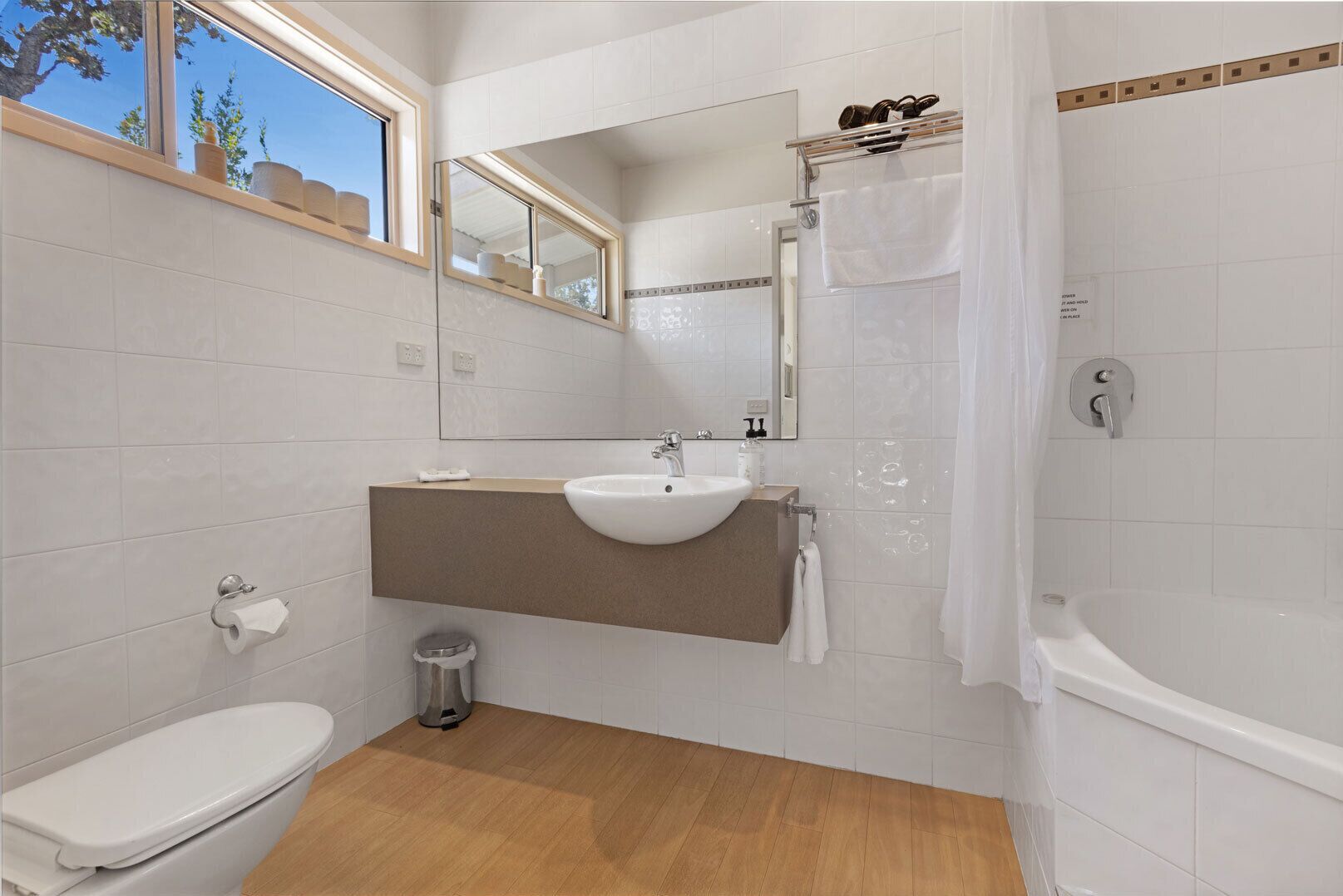 Un baño moderno con inodoro, lavabo y ducha.