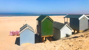 A beach with several small, simple beach huts. - Host & Stay | Laylands Yard (Wells-next-the-Sea)