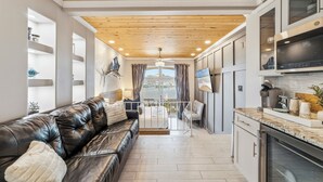 A modern kitchen with built-in appliances, a dining area with a view, and a cozy seating area with a leather sofa. - Inn at Camachee Harbor by Coolvacay (St. Augustine)