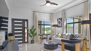 A modern living room with a sofa, coffee table, and a ceiling fan. - Zuma Villa/3BR/3.5BA/Rooftop Terrace/Sea View/Pool/Gated/10 mins to Beach/Swings (Ocho Rios)