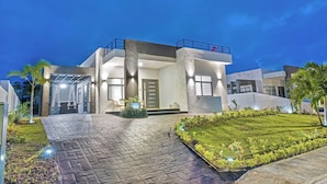 A modern two-story house with a paved driveway, a well-maintained lawn, and outdoor seating area. - Zuma Villa/3BR/3.5BA/Rooftop Terrace/Sea View/Pool/Gated/10 mins to Beach/Swings (Ocho Rios)