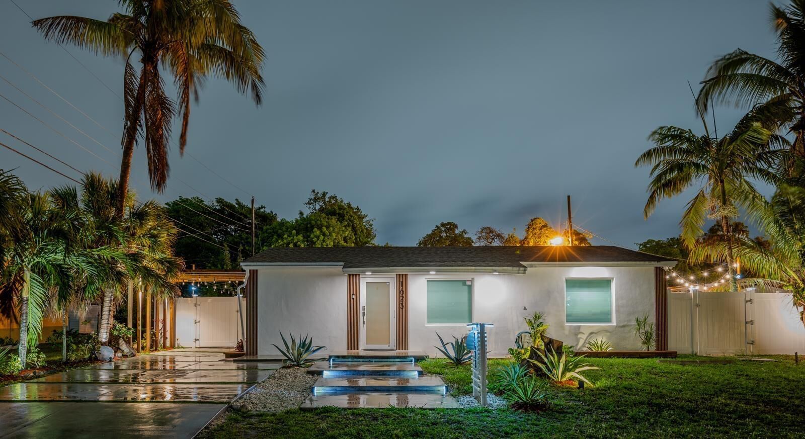 Ein modernes Haus mit Veranda, Garage und gepflegtem Rasen.