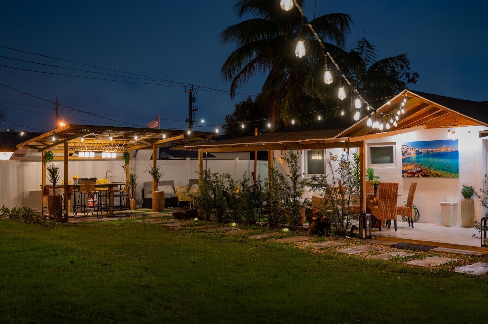 A house with a covered patio, outdoor furniture, and string lights.