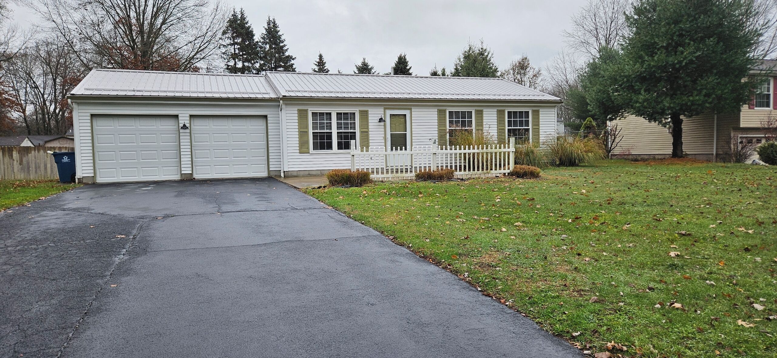 A two-story house with a garage, a front porch, and a well-maintained lawn.