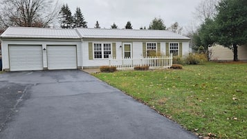 A two-story house with a garage, a front porch, and a well-maintained lawn.