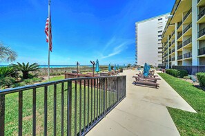 A hotel with a pool area, outdoor seating, and a view of the ocean. - FREE Golf & Perks! Mariner West 609 Beachfront Swimming Pool, Tennis, Grills! (Panama City Beach)