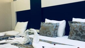 Una habitación de hotel con una cama, almohadas y cabecero.