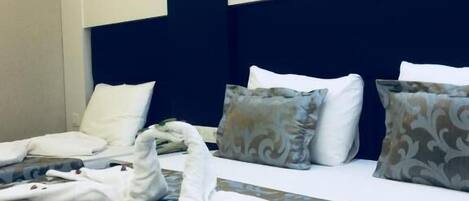 Una habitación de hotel con una cama, almohadas y cabecero.