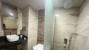 Un baño moderno con lavamanos grande, inodoro y zona de ducha.