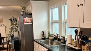 A kitchen with a refrigerator, dishwasher, and sink.