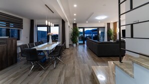 Un intérieur moderne comprenant un coin repas, un canapé et un escalier.