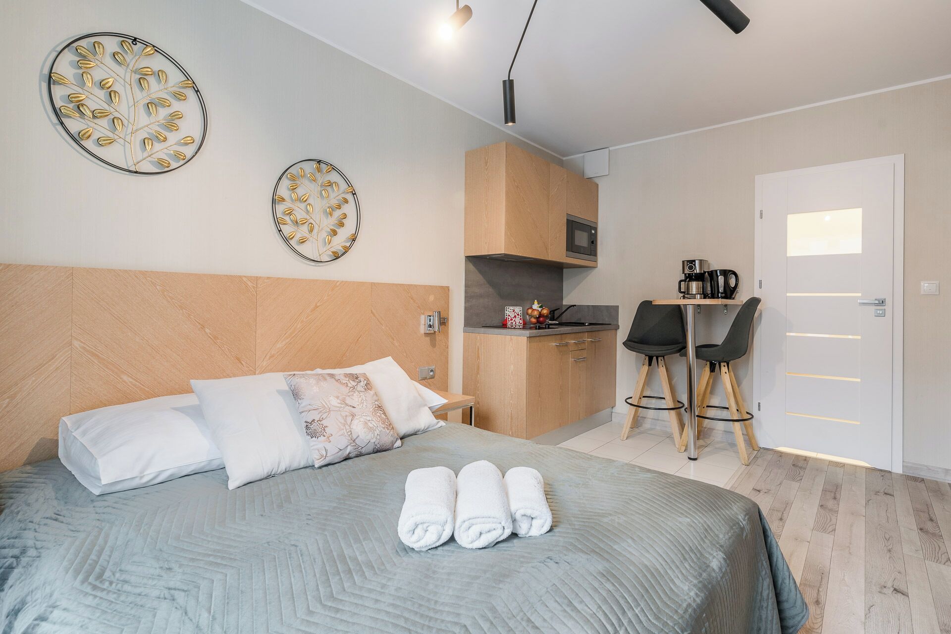 Una moderna camera d'albergo con un letto grande, angolo cottura e zona pranzo.