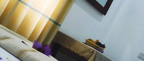 Una habitación de hotel con cama, chimenea y espejo en la pared.