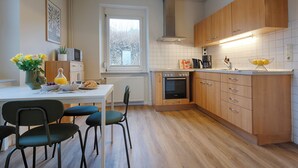 Una cucina moderna con mobili in legno, forno integrato e zona pranzo con tavolo e sedie.