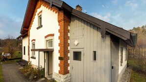 Un edificio a due piani con facciata in mattoni e una porta grigia.