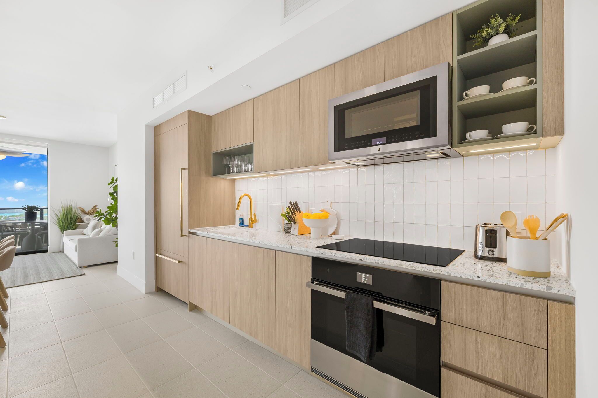 A modern kitchen with wooden cabinets, a microwave, a toaster, and a sink.