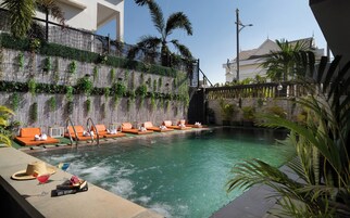 Una piscina al aire libre, camas de piscina gratis, sombrillas