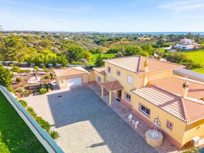 A large house with a spacious courtyard, multiple rooms, and a view of the surrounding landscape. - Villa Golden Bay (Lagoa)