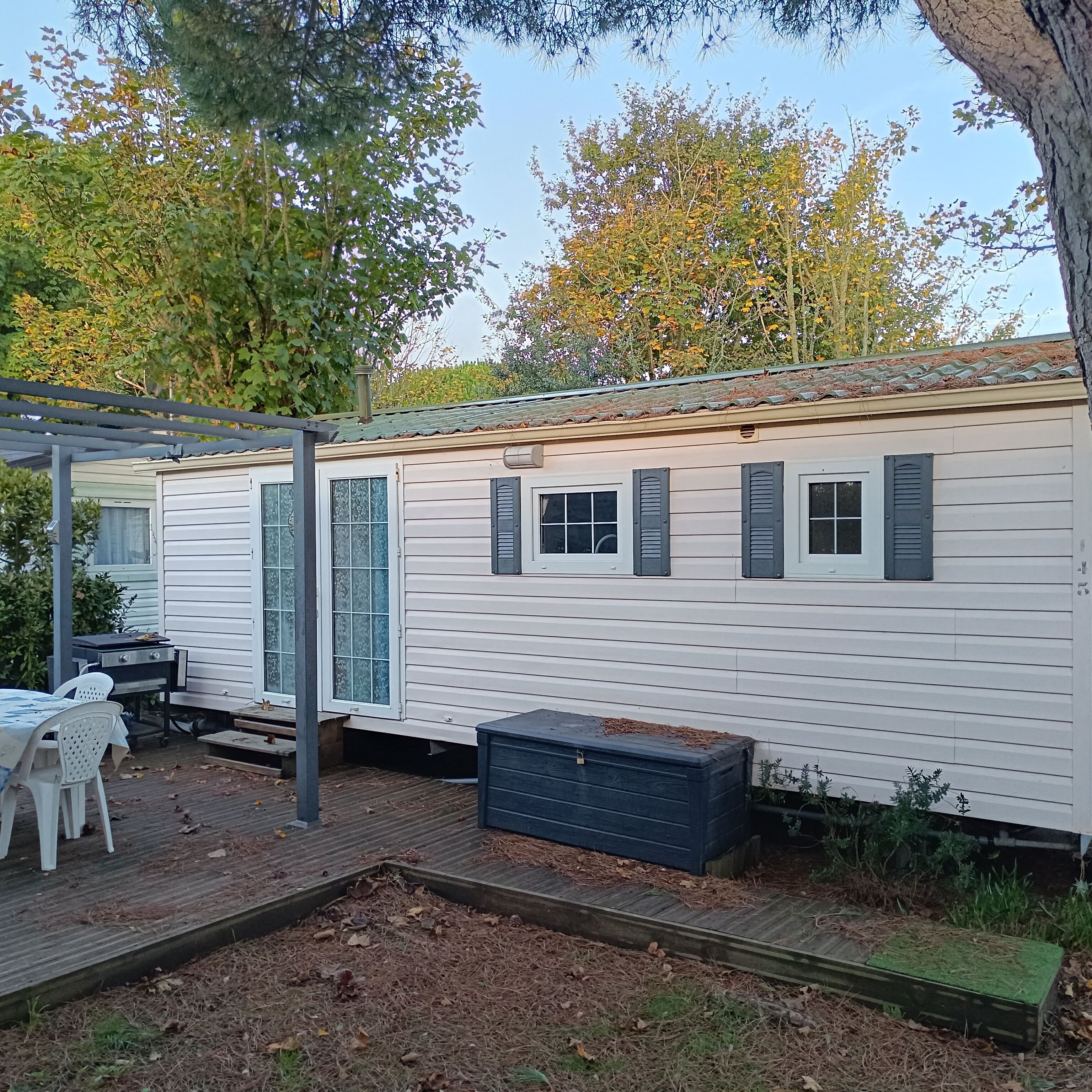 Una casa móvil con un patio, una mesa y sillas.