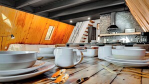 A dining area with wooden tables, white plates, and cutlery.