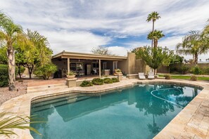 A modern house with a swimming pool, patio furniture, and palm trees. - Sunny Scottsdale Escape: Glow Golf, BBQ & Pool (Scottsdale)