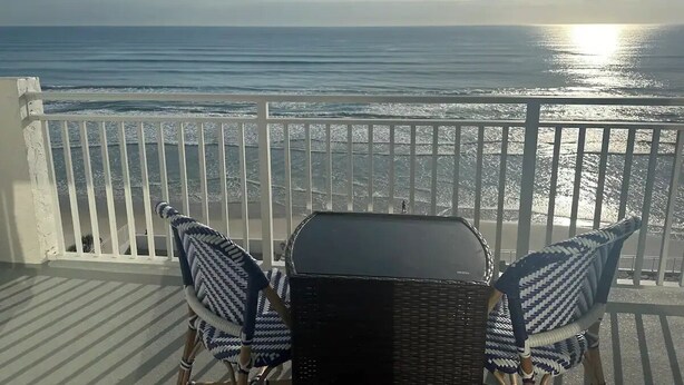 A balcony with a view of the ocean, a table, and two chairs. - Ocean View 7th floor Condo on Daytona Beach!

 (Daytona Beach Shores)
