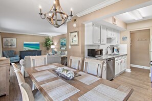 A modern kitchen with white cabinets, a stainless steel dishwasher, and a microwave.