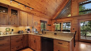 Cucina spaziosa con pensili in legno, piani in granito e lavastoviglie.