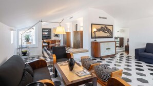 Ein modernes Wohnzimmer mit Schachbrettmuster-Boden, einer Couch, einem Couchtisch und einem Gemälde an der Wand.
