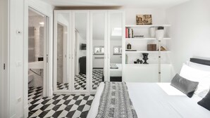 Ein Schlafzimmer mit einem Bett, einem Nachttisch, einem Bücherregal und einem Kleiderschrank.