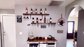 A kitchen with a wooden countertop, wine bottles on shelves, and coffee-related signs. - TERRA NOVA Spacious 4-bedroom house in Phoenix AZ, 7 minutes from Downtown. (Phoenix)