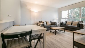 Uma sala de estar moderna com uma mesa de jantar, dois sofás e uma mesa de centro.