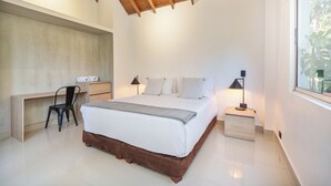 Ein Schlafzimmer mit hölzernem Bettgestell, einem Schreibtisch, einem Stuhl und einem Nachttisch mit Lampe.