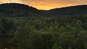 A forested valley with a sunset sky. - The Stillwater Suite, named after the serene stillness of its surroundings and the moments where the lake is as still as glass. (Jasper)