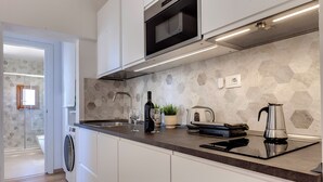A modern kitchen with a built-in oven, microwave, and stainless steel kettle. - Mamo Florence - Sacha Apartment (Florence)