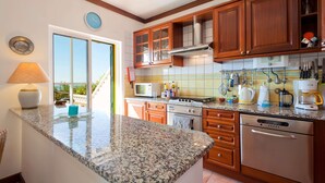 Una cocina con encimeras de granito, armarios de madera y electrodomésticos de acero inoxidable.