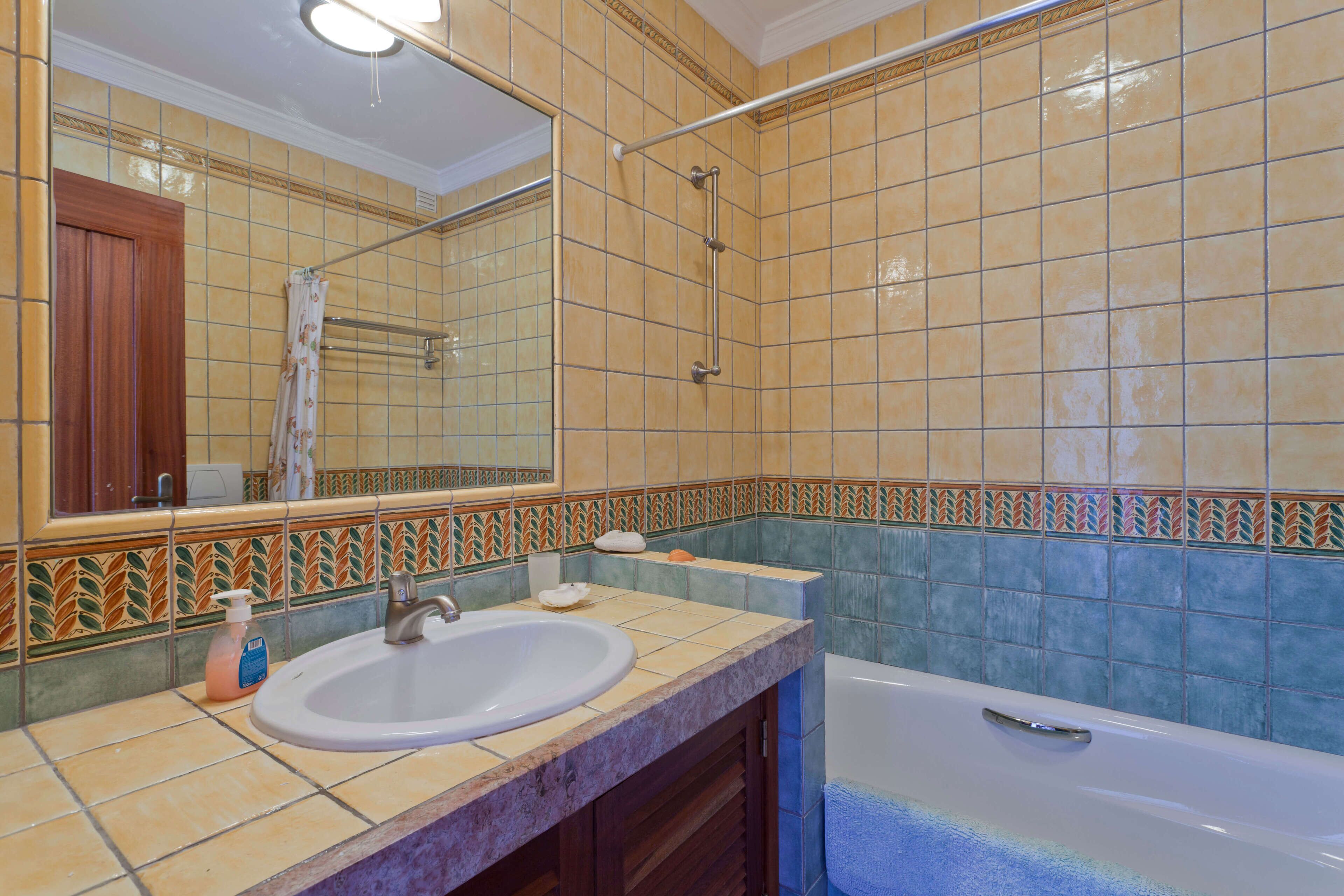 A bathroom with a sink, mirror, shower, and bathtub.