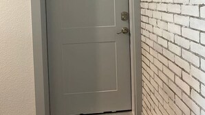 A white door with a number plate '12' above it, a doorbell, and a doorbell button. - Elizabeth Manor in Downtown Huntsville (Huntsville)