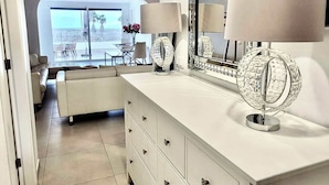 A modern bathroom with a white vanity, a large mirror, and two crystal lamps.