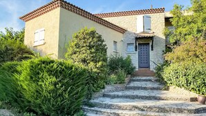 A two-story house with a stone facade, a tiled roof, and a front door with a small porch. - Bastide in Nîmes ⭐️⭐️⭐️ (Nîmes)