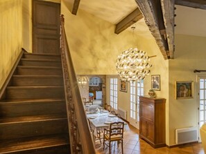 Enjoy meals in this elegant dining area with a high ceiling, chandelier, and kitchen view.