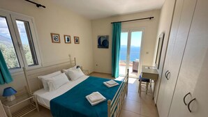 Una camera da letto con un letto, una scrivania e vista mare.