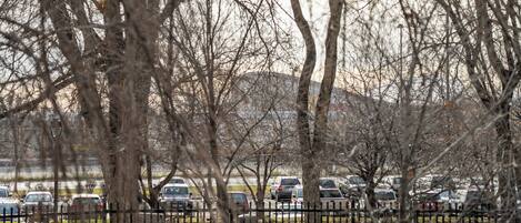 A parking lot with multiple cars and a fence.