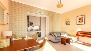 Un salon moderne avec un coin repas, un canapé, une table basse et une cuisine en arrière-plan.